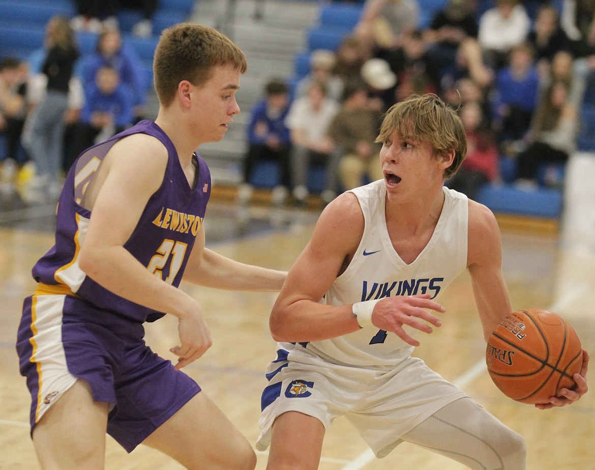 JASON ELLIOTT/Press
Coeur d'Alene junior guard Logan Orchard looks to throw the ball into the key past the defense of Lewiston's Karson Mader during the fourth quarter of Tuesday's game at Viking Court.
