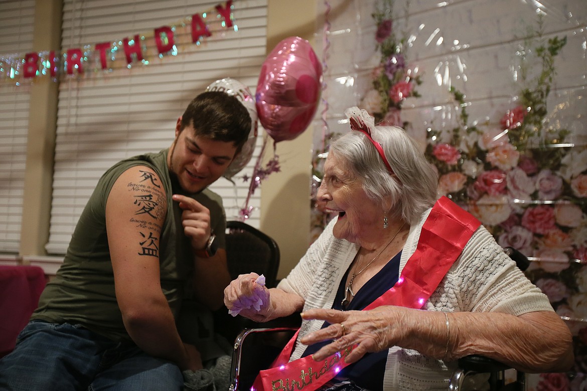 Dalton Clifton on Tuesday evening shows his great-grandmother Dixie Milliken his first tattoo, which he got in her honor and includes flowers she drew, during her 101st birthday celebration at the Lodge at Bristol Heights.