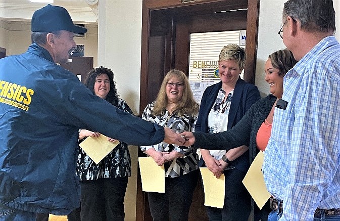 Coroner Ron Hodge presents his badge to daughter Carrie at the Benewah County swearing-in ceremonies Jan. 9.