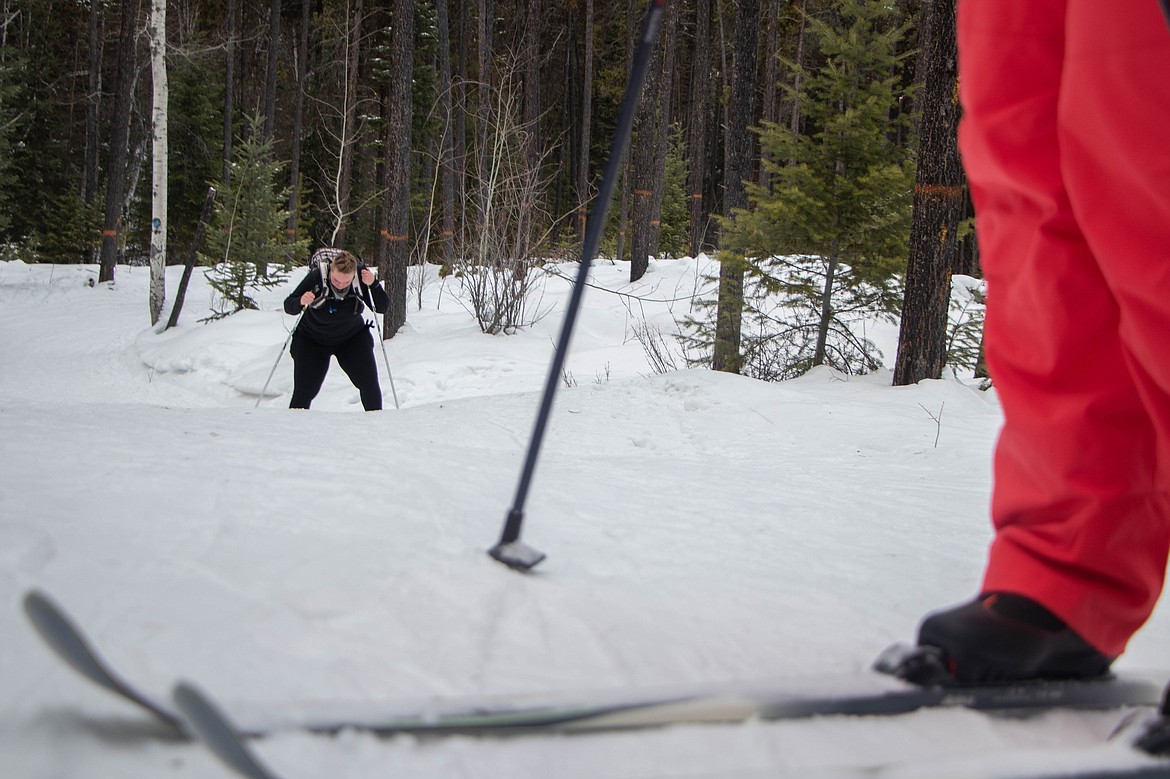 Julia Velky, in the background, skis up a hill at Round Meadow Trail in Whitefish on Jan. 25, 2023. (Kate Heston/Daily Inter Lake)