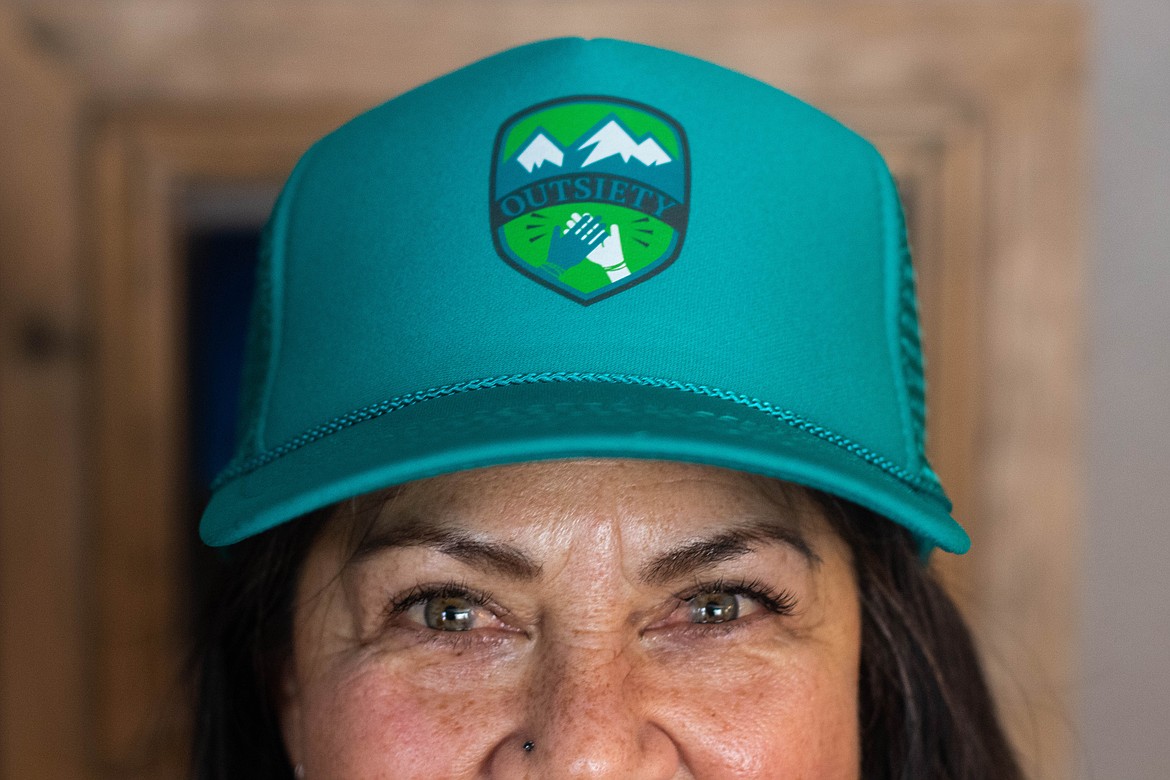 Laurie McCargar poses for a portrait at her home wearing an Outsiety hat on Jan. 27, 2023. (Kate Heston/Daily Inter Lake)