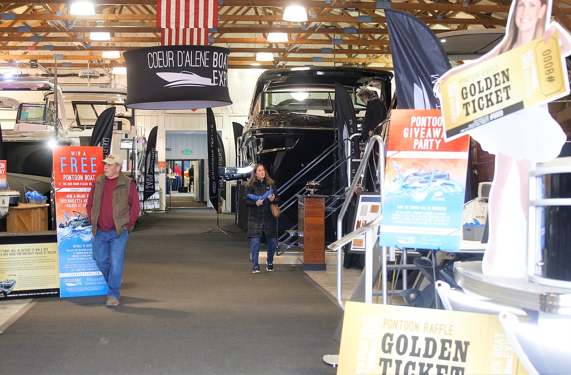 Mike DuBose of Coeur d'Alene, left, checks out boats in the fourth annual Coeur d’Alene Boat Expo at Hagadone Marine Center on Wednesday.