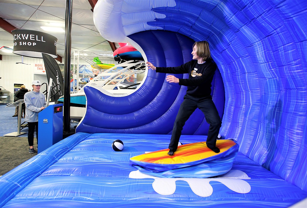 Grant O'Brien tries out the surf machine at the Coeur d’Alene Boat Expo at Hagadone Marine Center on Wednesday.