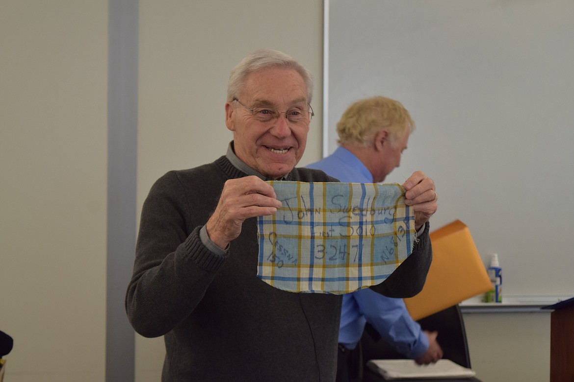 Retired Big Bend Community College flight instructor John Swedburg holds up a portion of the shirt he wore when he flew his first solo flight in March 1971. Swedburg was honored on Saturday with the Federal Aviation Administration’s highest award for civilian pilots, the Wright Brothers Master Pilot Award, given to pilots with 50 or more years of flying.