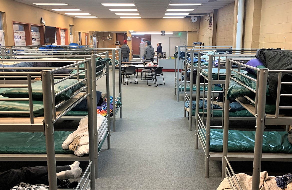 Guests and staff talk in the St. Vincent de Paul North Idaho's warming shelter in Post Falls, while others rest in bunk beds on Wednesday