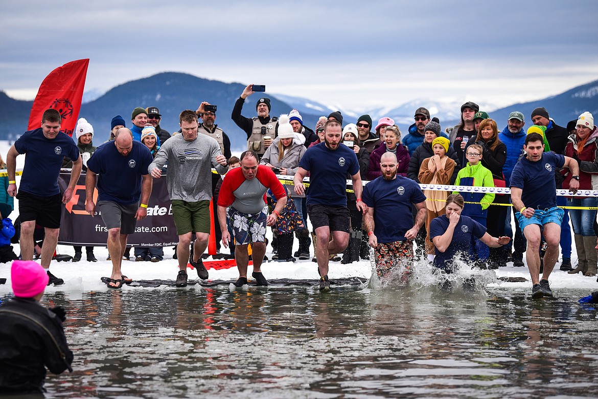 Members of the Whitefish Police Department leap into Whitefish Lake during the Penguin Plunge on Saturday, Feb. 4. Organized by the Law Enforcement Torch Run, as part of the Whitefish Winter Carnival, the event raised over $75,000 for Special Olympics Montana. (Casey Kreider/Daily Inter Lake)