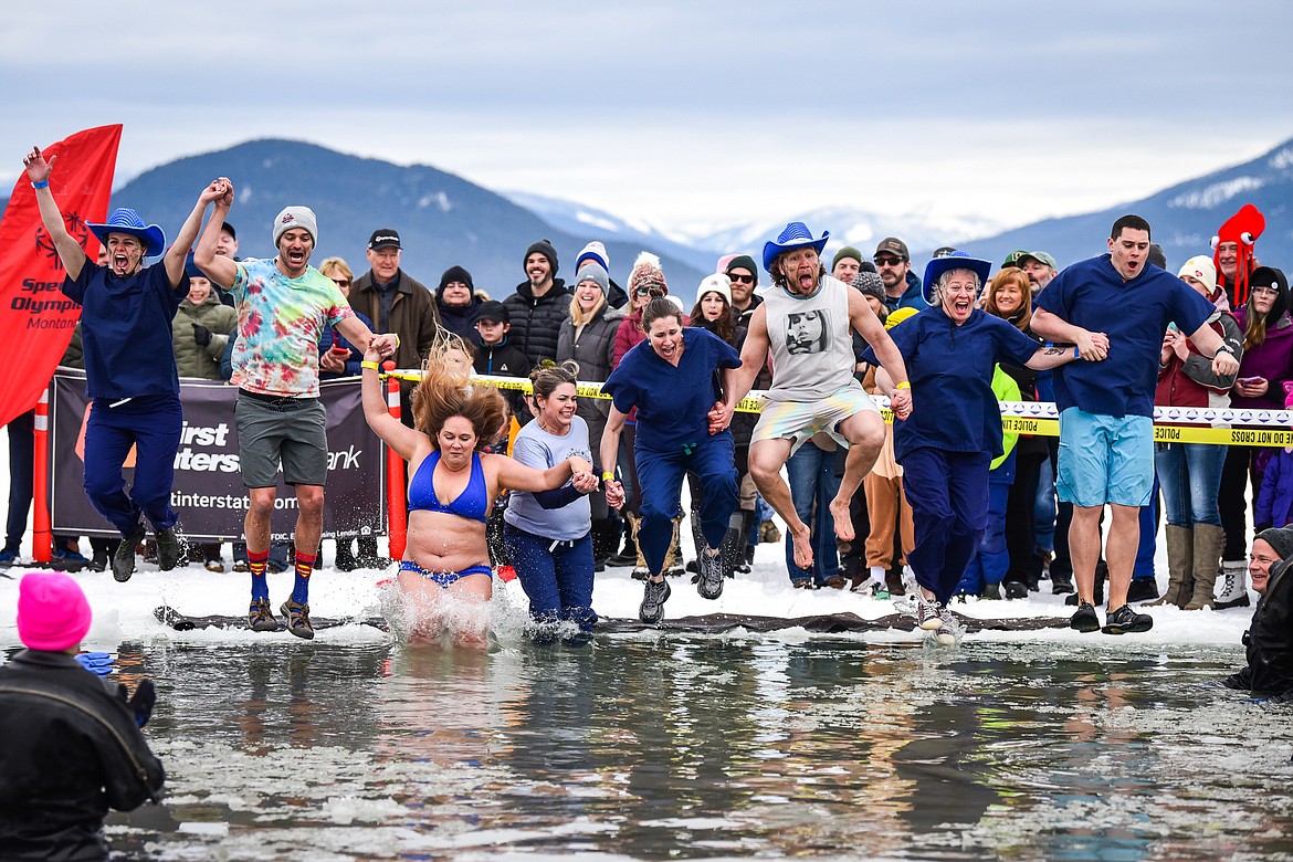 Participants from North Valley Hospital leap into Whitefish Lake during the Penguin Plunge on Saturday, Feb. 4. Organized by the Law Enforcement Torch Run, as part of the Whitefish Winter Carnival, the event raised over $75,000 for Special Olympics Montana. (Casey Kreider/Daily Inter Lake)