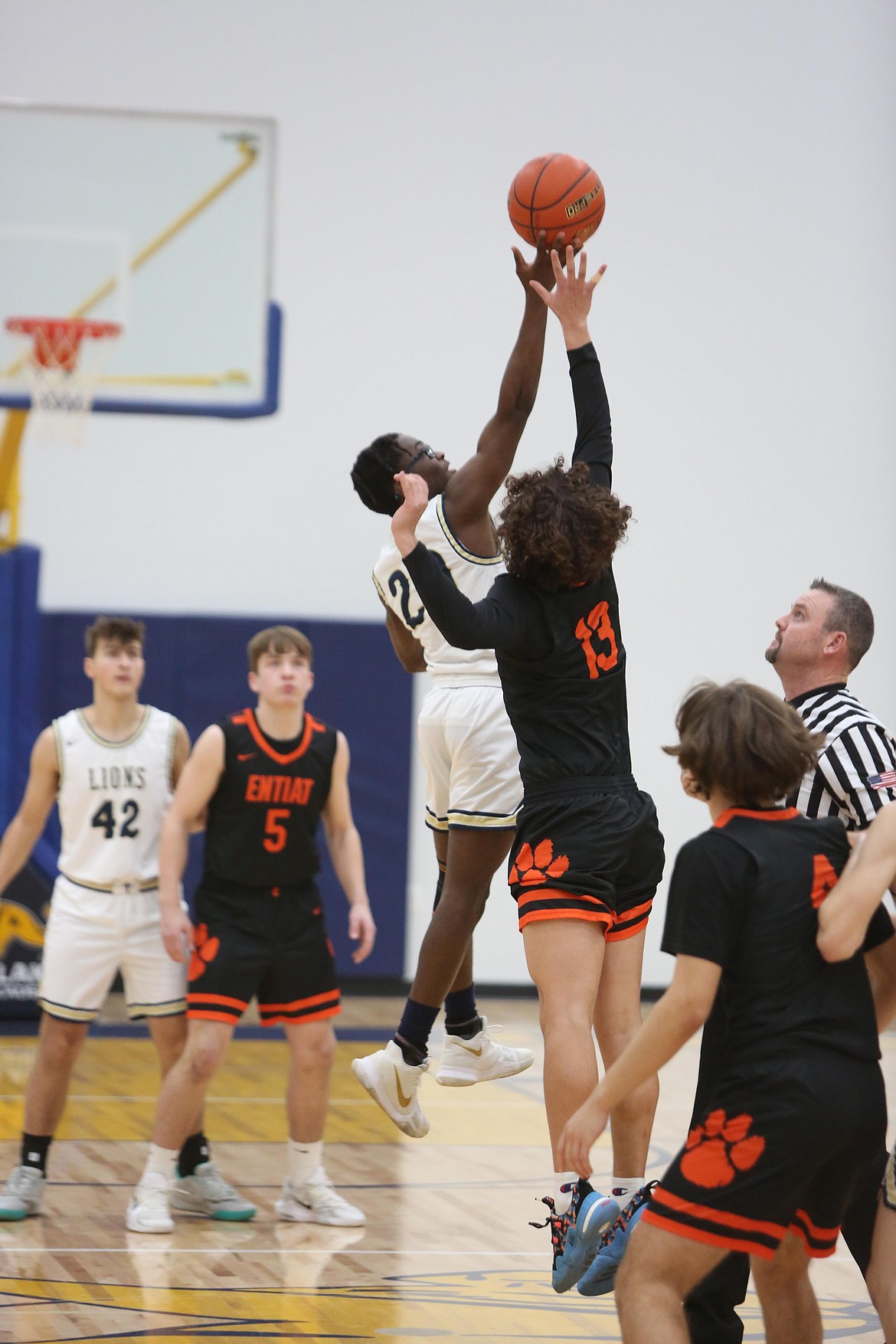 MLCA/CCS senior Jeff Boorman, center left, leaps up for the opening tip-off against Entiat on Friday night.