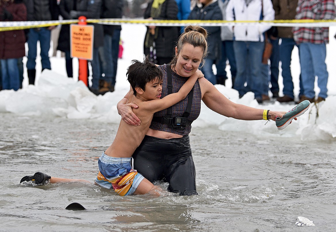 Chilly participants try to get out of the cold water after jumping at the Penguin Plunge on Saturday at City Beach. (Whitney England/Whitefish Pilot)