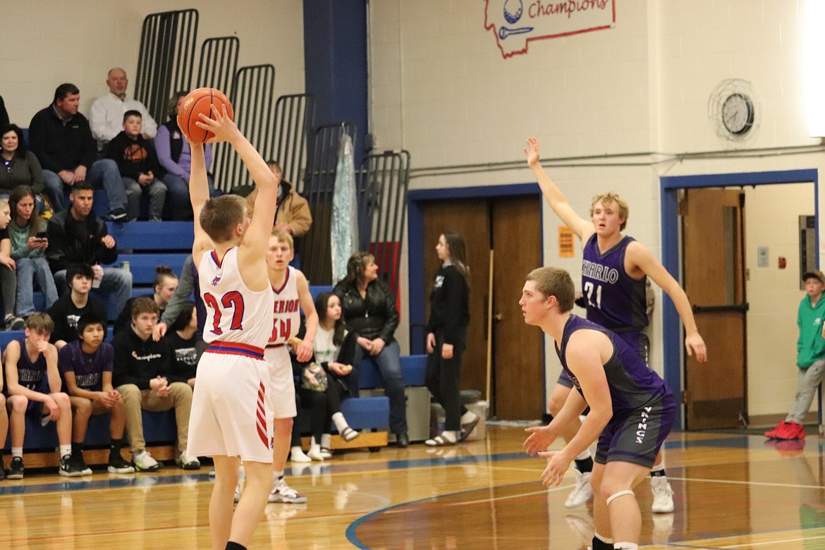 Bobcats forward Tucker Donaldson looks for an open pass while being defended by Charlo's Tucker Love (foreground right) and Stetson Reum (21) during their game Saturday night in Superior.  (Photo by Kami Milender)