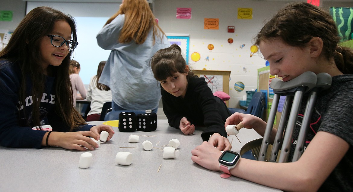 From left, Angelith Bautista, Hadley Yake and Mikayla Kirk scramble to make 3D shapes out of toothpicks and marshmallows Monday during a STEM Book Club session at Skyway Elementary. The program is offered through the local education-centered nonprofit Growing the STEM.