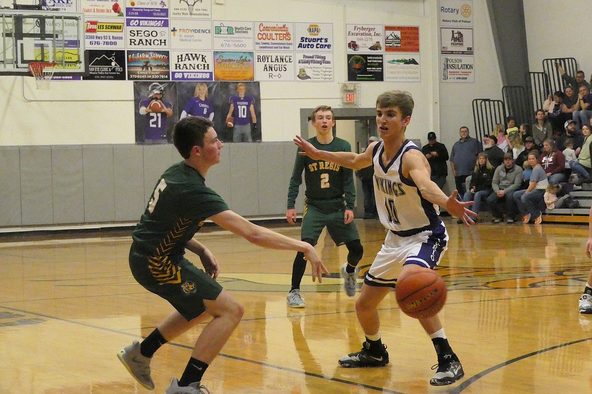 St. Regis junior Kaleb Park passes the ball around Charlo's Hayden Hollow during their game Friday night in Charlo, won by the Vikings. (Chuck Bandel/VP-MI