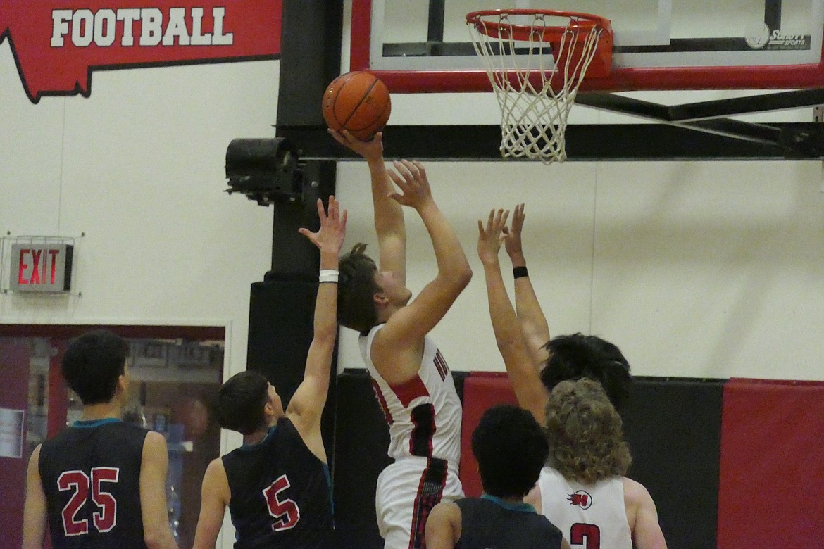 Savage Heat post Garth Parker goes up high for two points over a group of Two Eagle River players Saturday night in Hot Springs.  (Chuck Bandel/VP-MI)