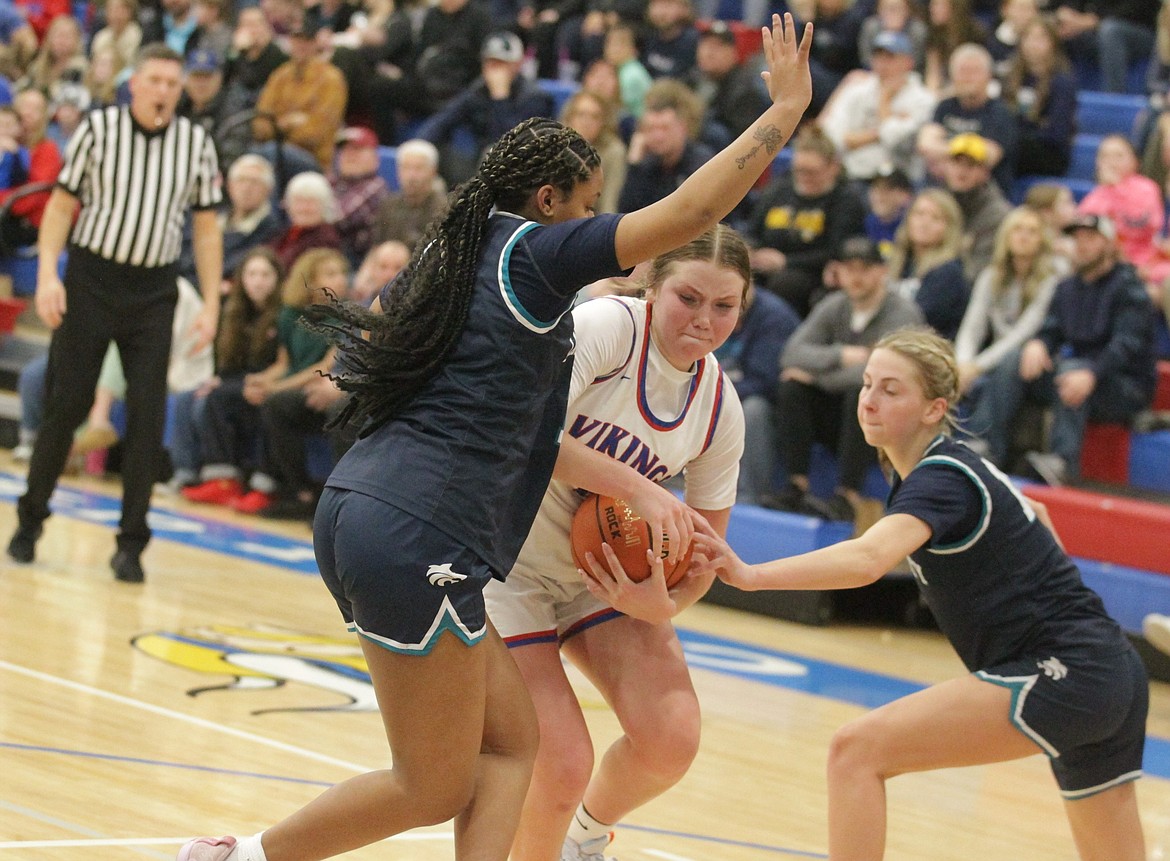 JASON ELLIOTT/Press
Coeur d'Alene senior Madi Symons (11) drives through the defense of Lake City's Kaliah Frazey, left, and Avery Waddington during the fourth quarter of Tuesday's 5A Region 1 girls basketball championship game at Viking Court.