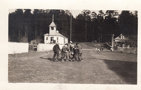 The Bigfork School with students playing. This school was located near where the tennis courts are today. (Credit – Jeff Wade Family Collection)