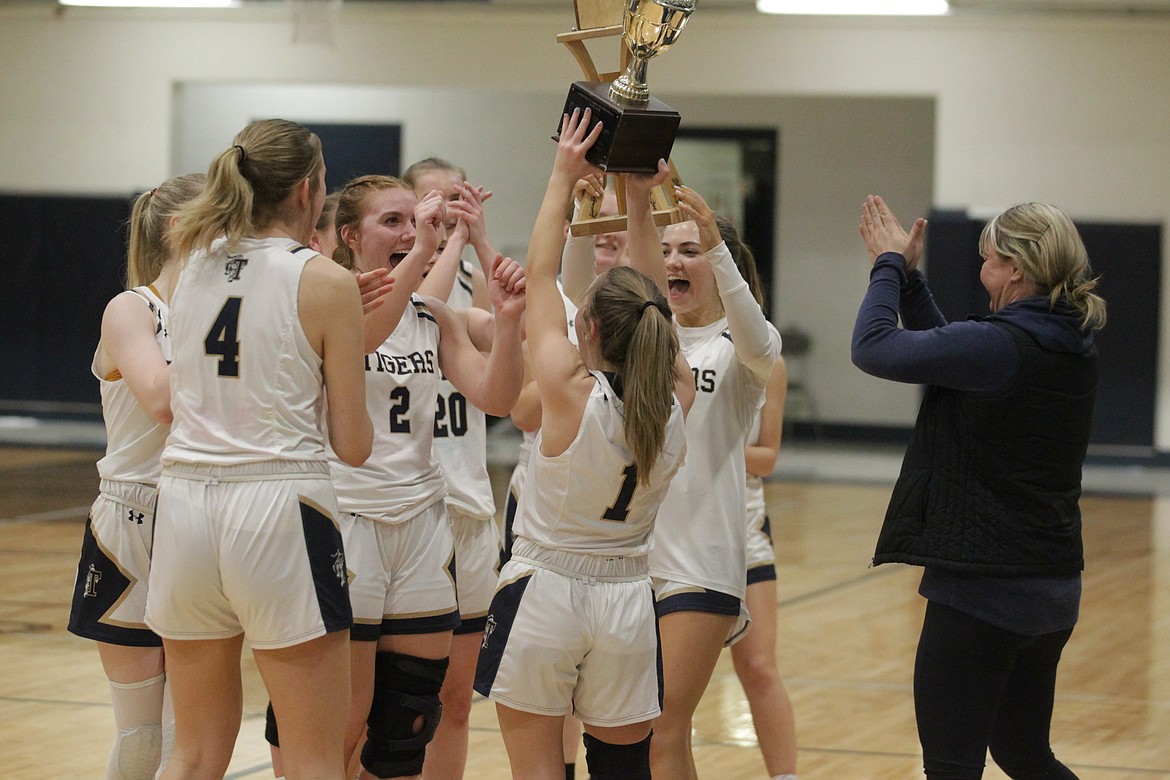 MARK NELKE/Press
Timberlake senior Ciara Soumas (1) holds the trophy aloft as teammates celebrate after the Tigers won the 3A District 1 girls basketball championship on Wednesday night in Spirit Lake.