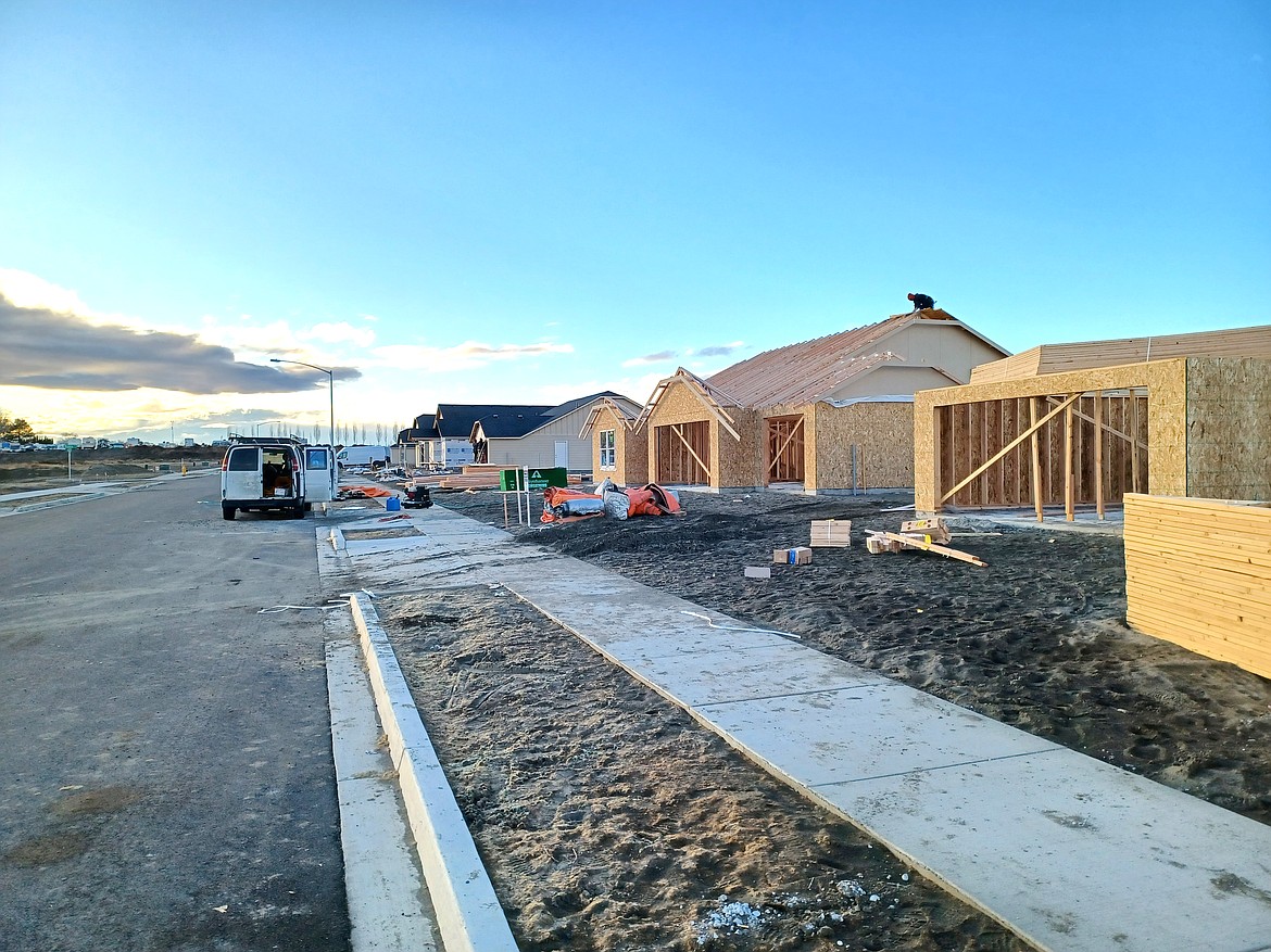 A worker puts the roof on a new home in the Refuge at Mae Valley on Tuesday. The development is one of many springing up where not so long ago there was only sagebrush and dust.