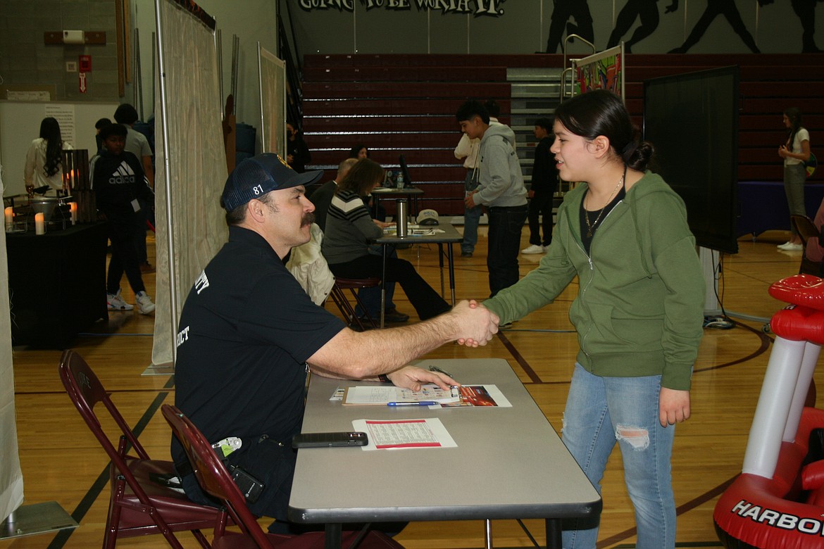 Giselle Madrigal, right, introduces herself to Grant County Fire District 8 Chief Matt Hyndman, left, during the Amazing Shake competition Feb. 3 at Wahluke Junior HIgh.