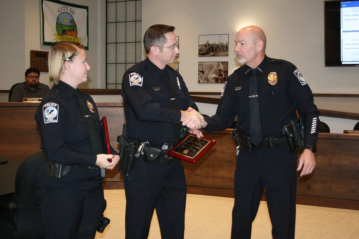 Quincy Police Chief Kieth Siebert, right, presents an award to QPD officer Stephen Harder, left, and QPD Sergeant Jazzlynn Silva, center, recognizing their rescue of a woman from a burning house Jan. 10.