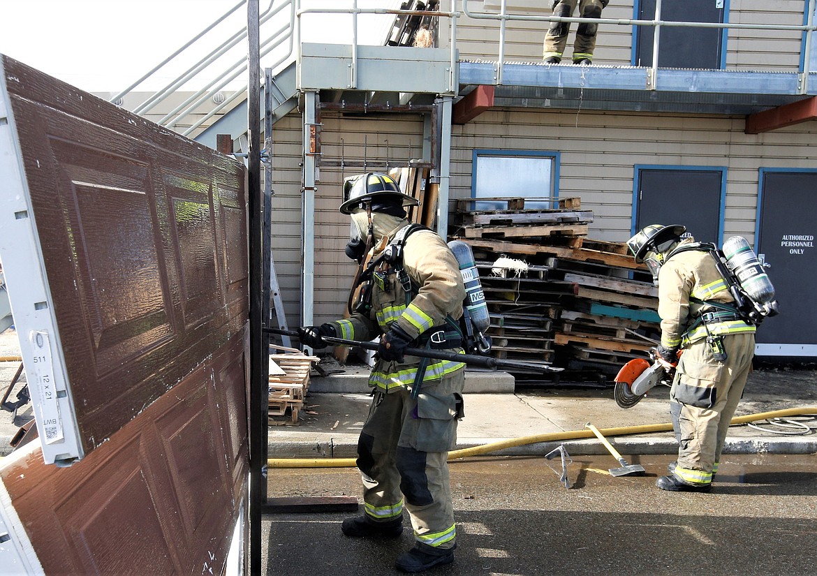 A Coeur d'Alene firefighter cuts through a garage door during exercises at the training facility behind Fire Station 2 on Thursday.