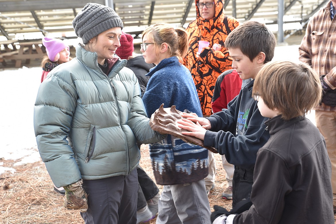 Annie Gassman shows Libby Elementary School students a cast of a grizzly bear track Friday morning at the Friends of Scotchman Peaks Wilderness event at J. Neils Memorial County Park. (Scott Shindledecker/The Western News)