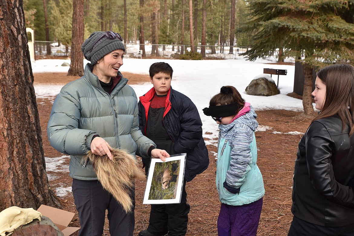 Annie Gassman shows Libby Elementary School students a piece of grizzly bear hide Friday morning at the Friends of Scotchman Peaks Wilderness event at J. Neils Memorial County Park. (Scott Shindledecker/The Western News)