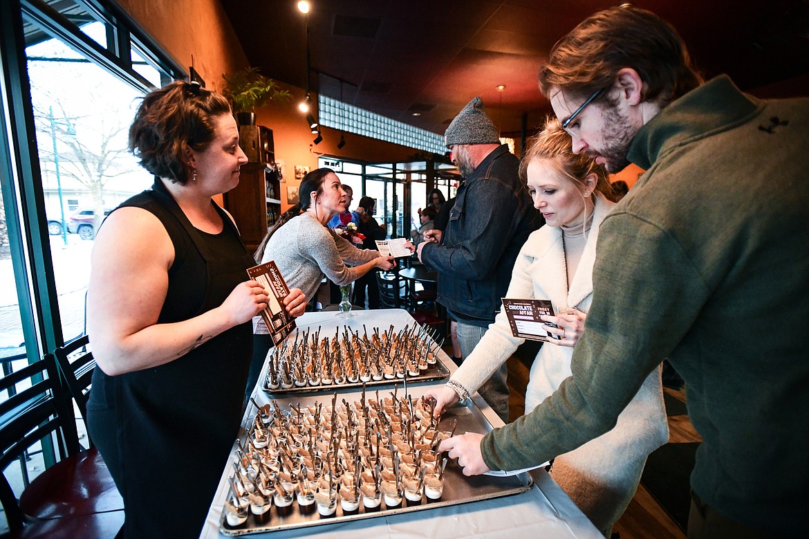 From left, Bonelli's Bistro baker Megan Groves and owner Maren Schuman hand out S'mores in a Cup treats during the Chocolate Affair event held by the Kalispell Downtown Association on Friday, Feb. 10. (Casey Kreider/Daily Inter Lake)