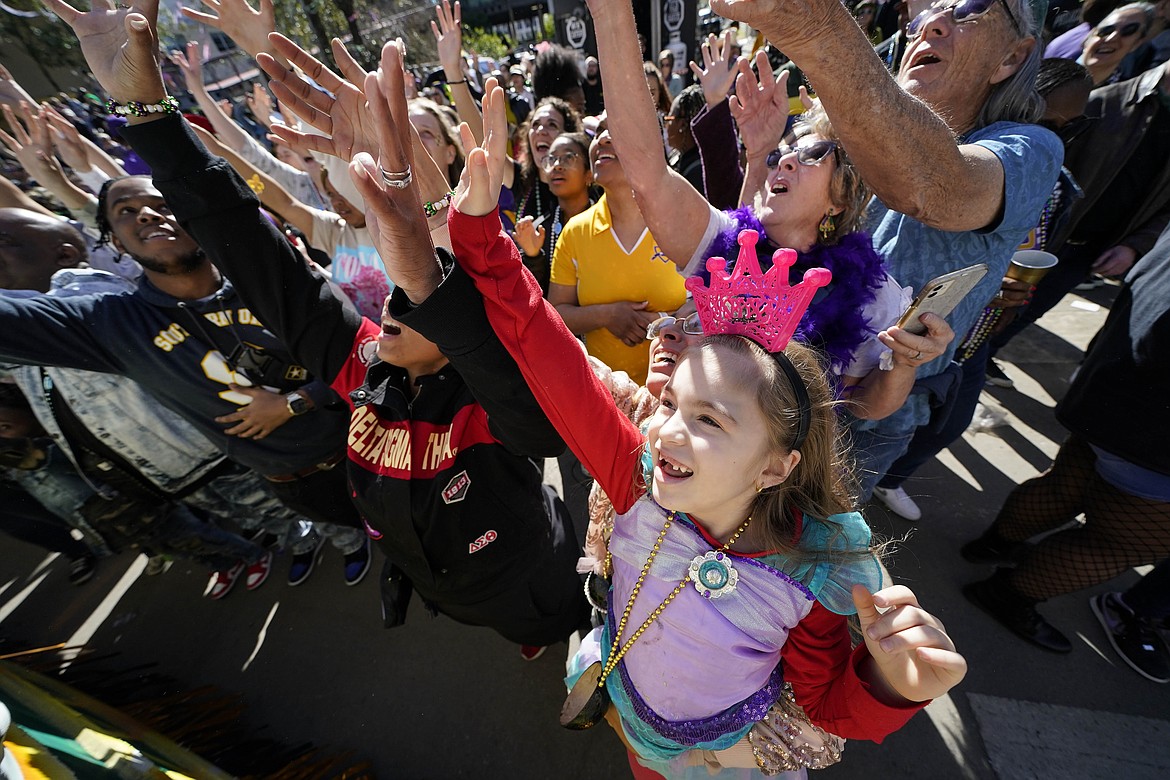 Emma Ferrebus, 5, of New Orleans, reaches for treats from the Krewe of Zulu parade during Mardi Gras on Tuesday, March 1, 2022, in New Orleans. The lead-up to New Orleans’ annual Mardi Gras celebration is intensifying with events big and small. Three parades are set for Friday, Feb. 10, 2023 along historic St. Charles Avenue in New Orleans. (AP Photo/Gerald Herbert, File)