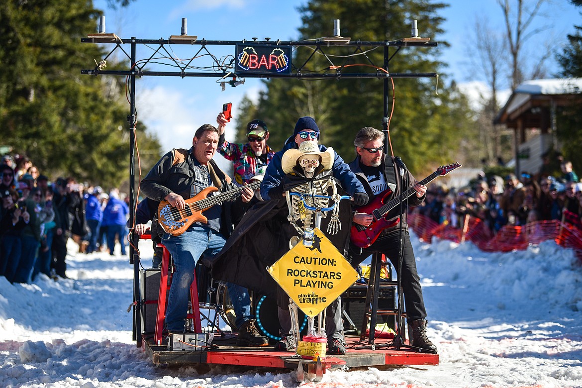 The band Playing in Traffic rides down Sugar Hill before the start of the Barstool Ski Races at Cabin Fever Days in Martin City on Saturday, Feb. 11. (Casey Kreider/Daily Inter Lake)