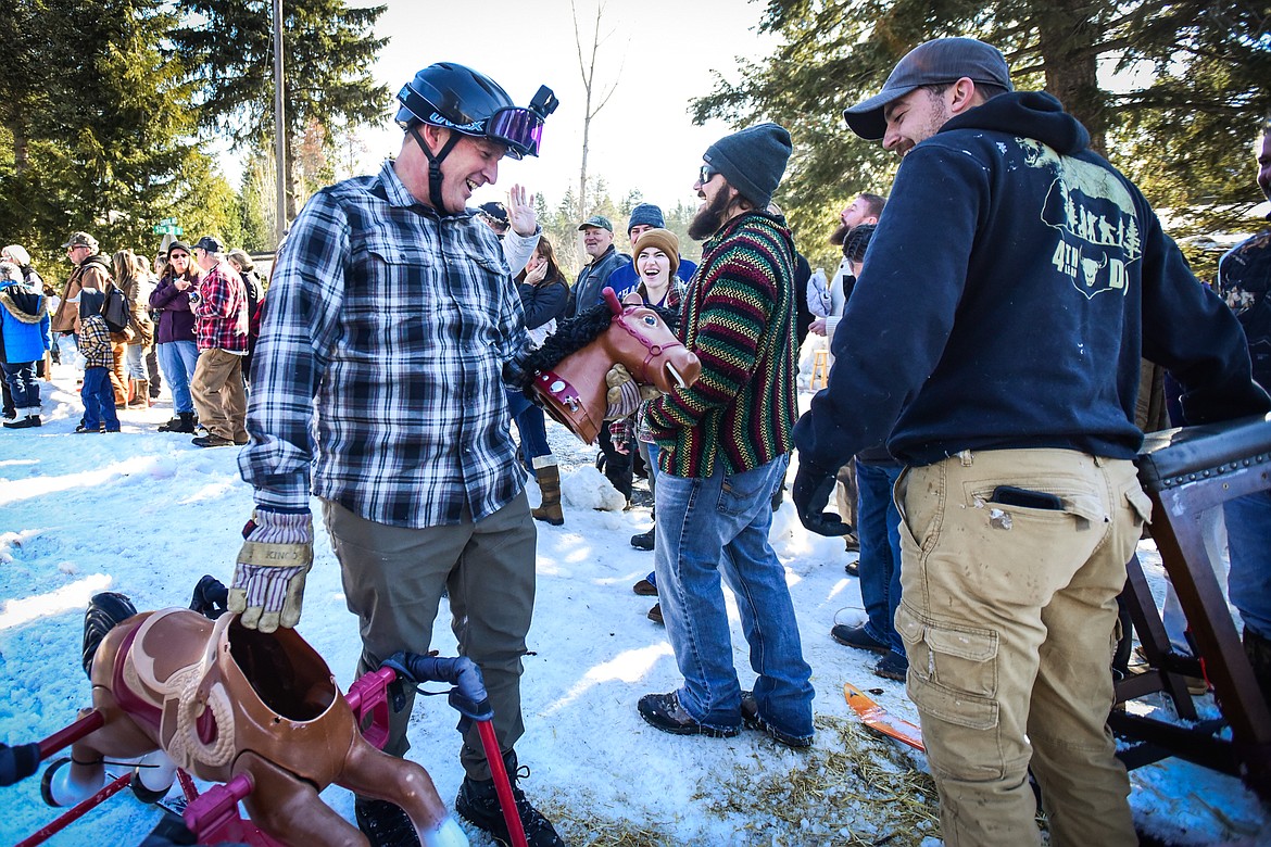 A participant laughs after his rocking horse barstool ski racer lost its head during the race at Cabin Fever Days on Saturday, Feb. 11. (Casey Kreider/Daily Inter Lake)