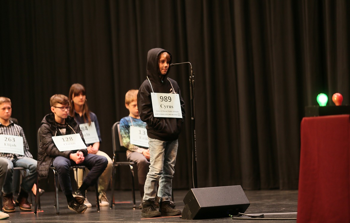 Bryan Elementary School fourth grader Cyrus Stockert grins as judges flash the green light for spelling a word right Saturday morning at the North Idaho Spelling Bee.