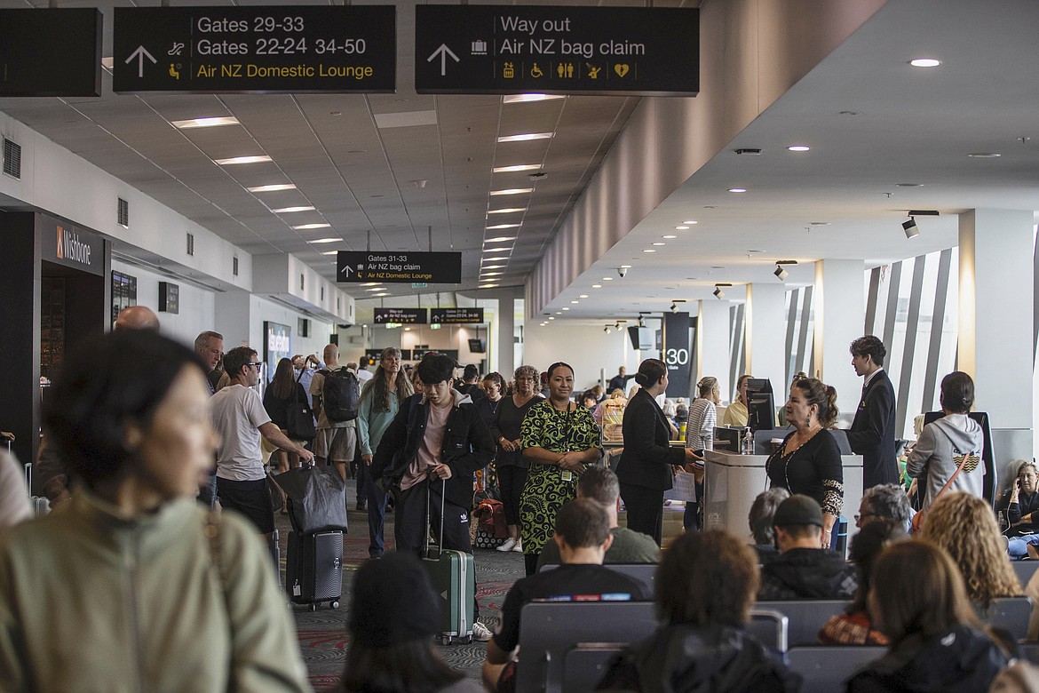 Passengers wait in departure lounges at Auckland Airport after flights were canceled and passengers stranded as a cyclone hit the northern parts of New Zealand, Sunday, Feb. 12, 2023. New Zealand's national carrier has canceled dozens of flights as Aucklanders brace for a deluge from Cyclone Gabrielle, two weeks after a record-breaking storm swamped the nation's largest city and killed several people. (George Heard/NZ Herald via AP)