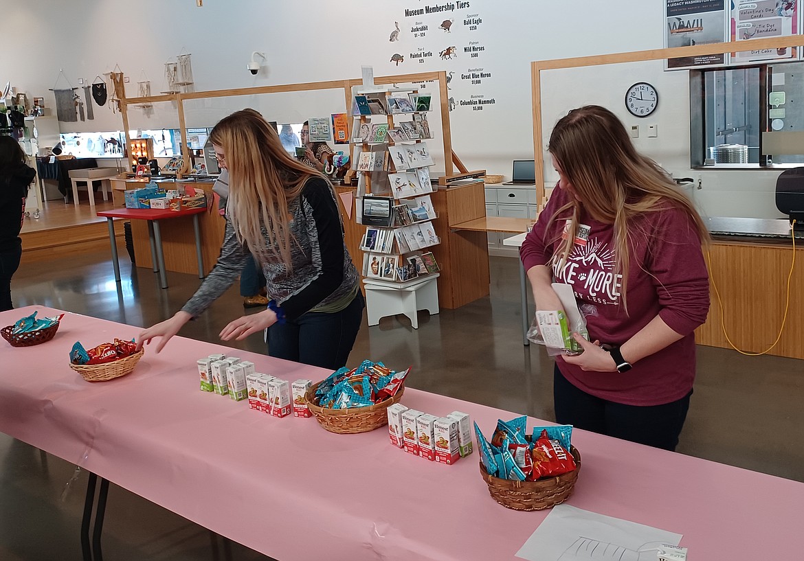 Museum staffers Colleen Seto, left, and Jamie Nixon lay out child-friendly refreshments for the Preschool Art Show reception Saturday.
