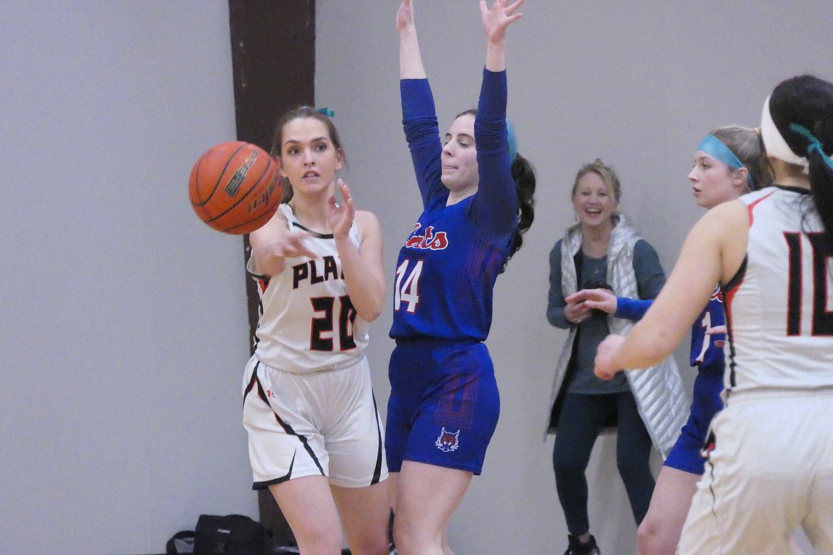 Plains senior guard Kassidy O'Keefe (20) passes to a teammate as Superior's Molly Patko looks on during their game Friday night in Plains.  (Chuck Bandel/VP-MI)