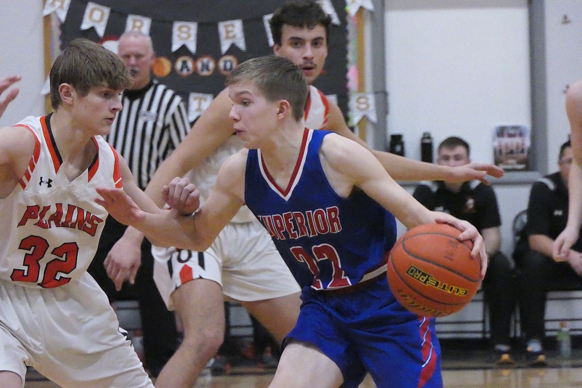 Superior's Tucker Donaldson (22, blue) dribbles toward the hoop while being guarded by Plains sophomore Zayden Allen during the game Friday night in Plains. (Chuck Bandel/VP-MI)