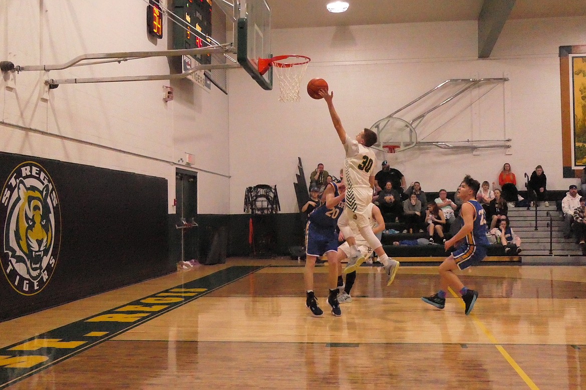 St. Regis sophomore forward Hunter Stolla goes high for a layup during St. Regis Saturday night victory over visiting Victor.  (Chuck Bandel/VP-MI)