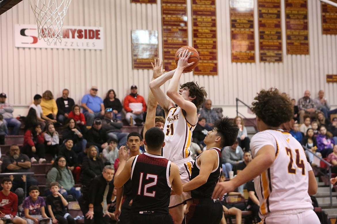 With a Sunnyside defender’s hand in his face, Moses Lake senior Jayson Byers takes a shot during the first half against Sunnyside on Jan. 27. Moses Lake travels to Sunnyside on Tuesday for a first-round matchup in the Columbia Basin Big 9 tournament.