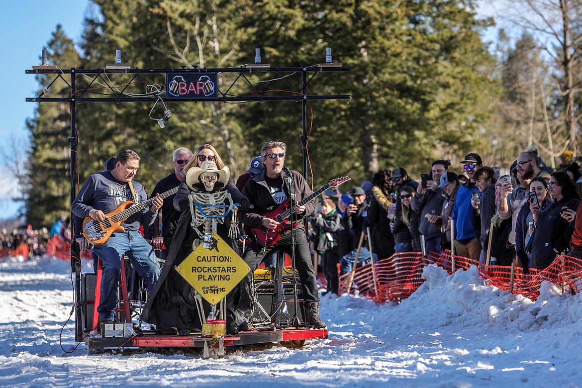 A band playing rock and roll music cruises down Sugar Hill in the Bar Stool Race in Martin City on Saturday. (JP Edge photo)