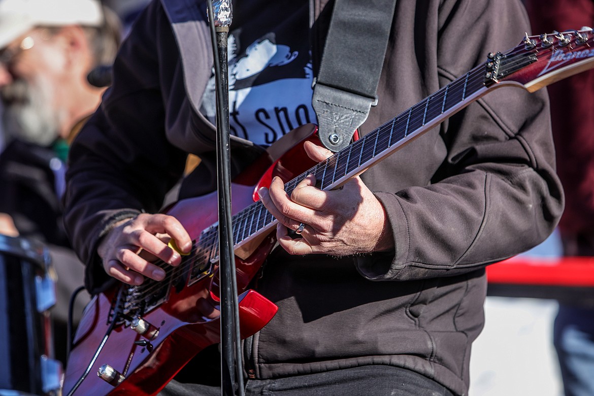 A band member plays a guitar solo at the finish line of the Bar Stool Race on Sugar Hill Saturday in Martin City. (JP Edge photo)