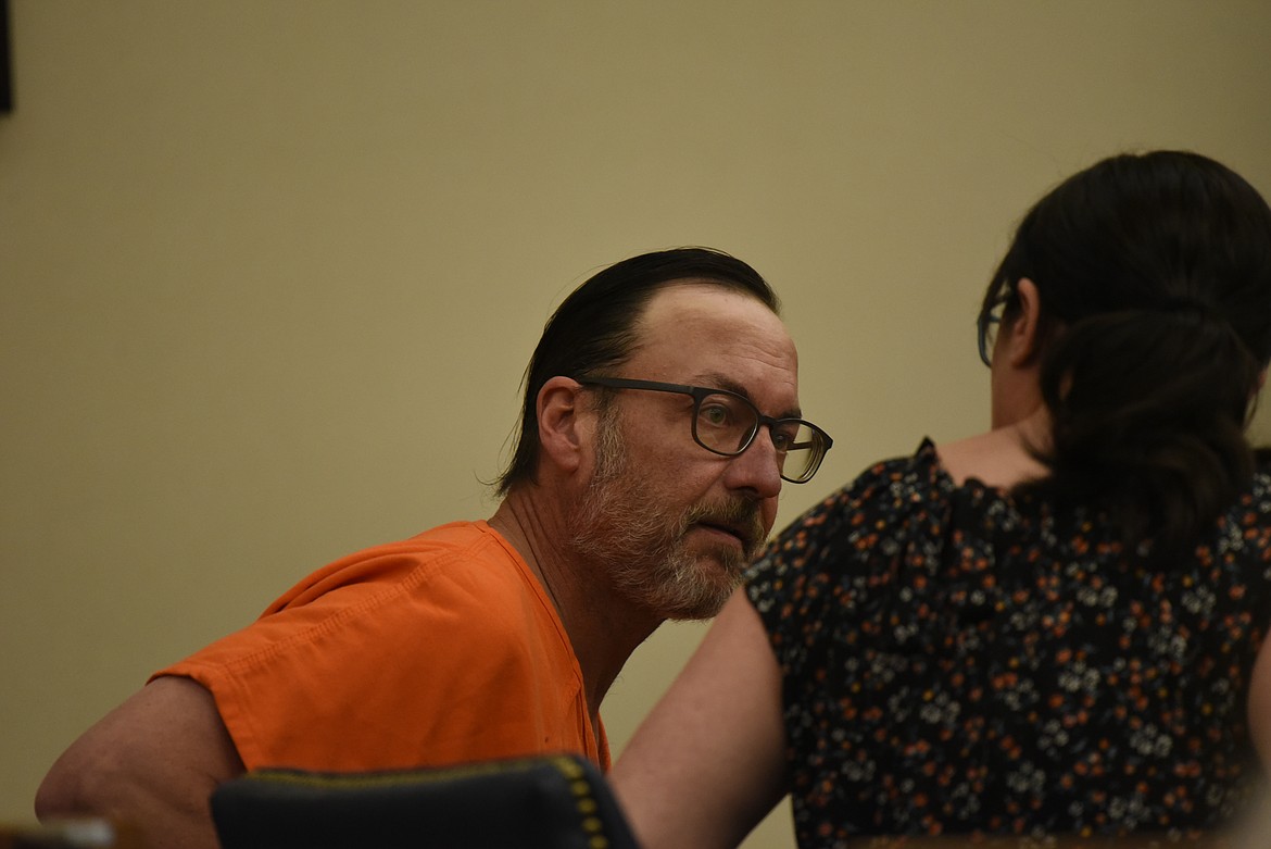 Jeffrey Allen Smith, charged with four counts of criminal endangerment, speaks with his defense attorney in Flathead County District Court on Feb. 9. (Derrick Perkins/Daily Inter Lake)