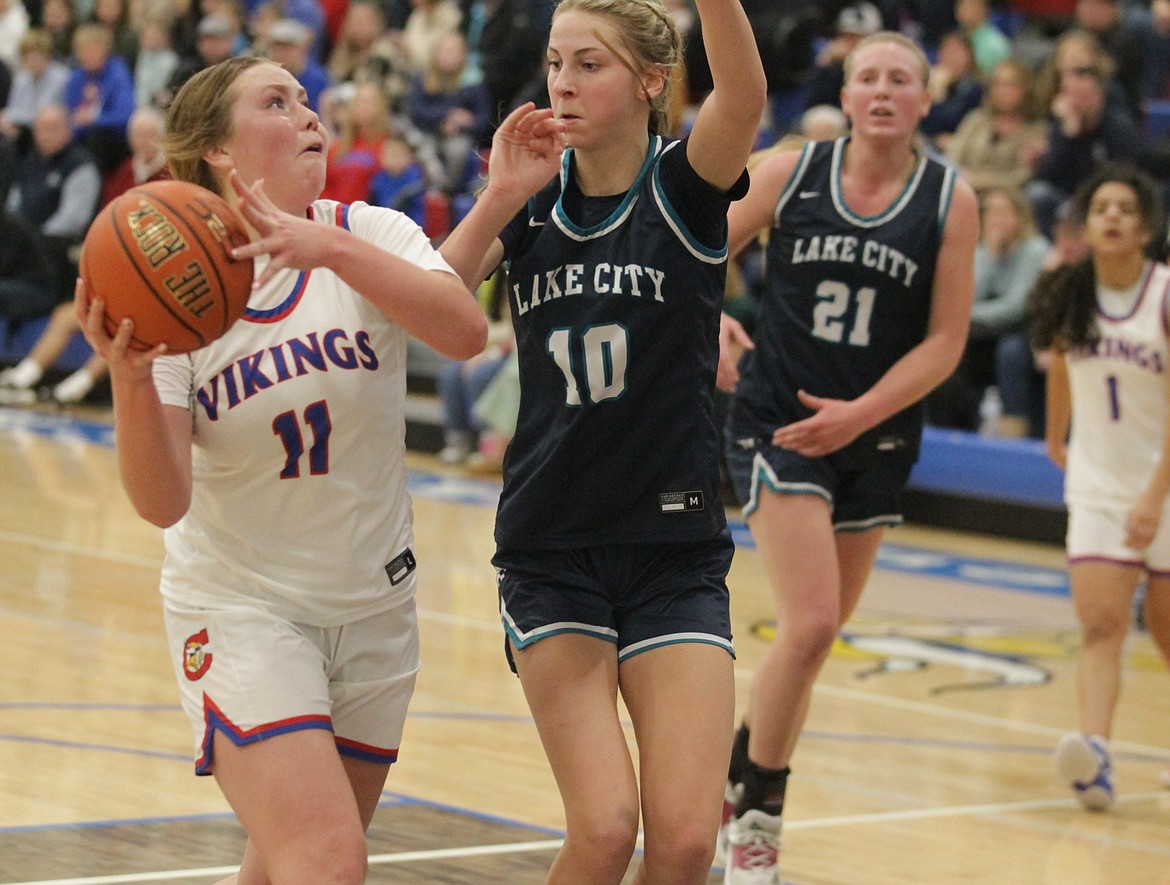 JASON ELLIOTT/Press
Coeur d'Alene senior forward Madi Symons goes up for a shot while Lake City junior guard Avery Waddington defends during the third quarter of the 5A Region 1 championship game on Feb. 7 at Viking Court.