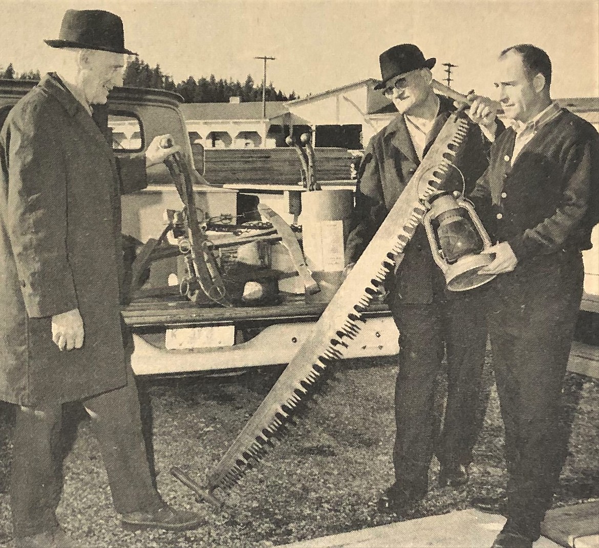 Selman Froisness, center, gives vintage lumbering equipment to Carl Kreuger, left, and Gardner Teall of the North Idaho Hoo Hoo Club.