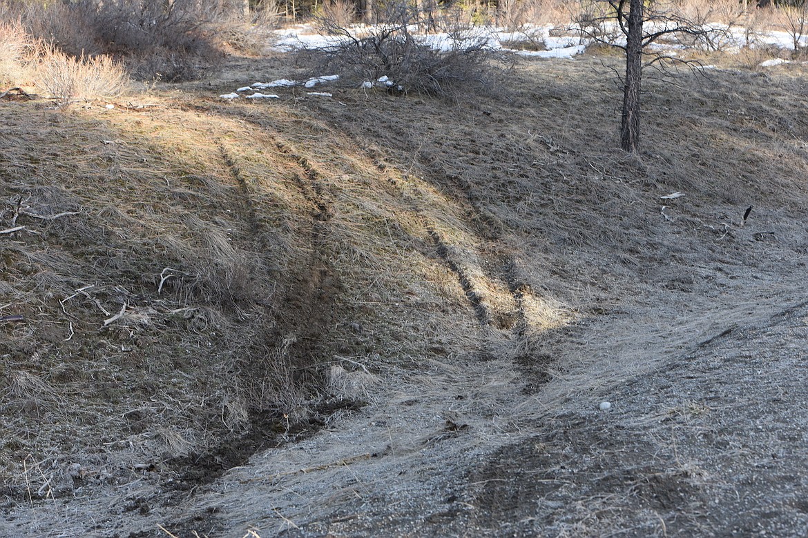 Tire tracks were visible in the soft ground Thursday evening off Montana Highway 37 near Camp Creek Road in northern Lincoln County where a police chase ended. A Montana Highway Patrol trooper was struck by the suspect vehicle and airlifted to Logan Health in Kalispell. (Scott Shindledecker/The Western News)
