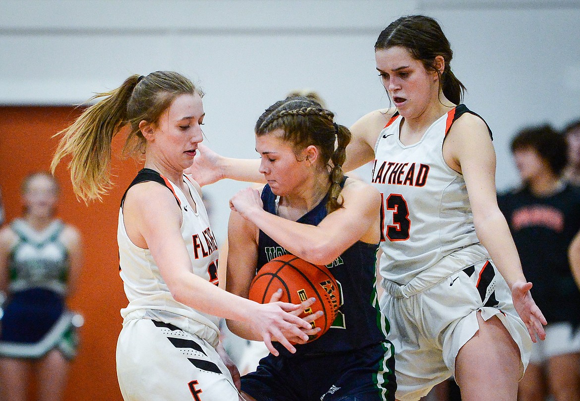 Flathead's Harlie Roth (20) and Avery Chouinard (13) defend against Glacier's Noah Fincher (22) in the second half at Flathead High School on Thursday, Feb. 16. (Casey Kreider/Daily Inter Lake)