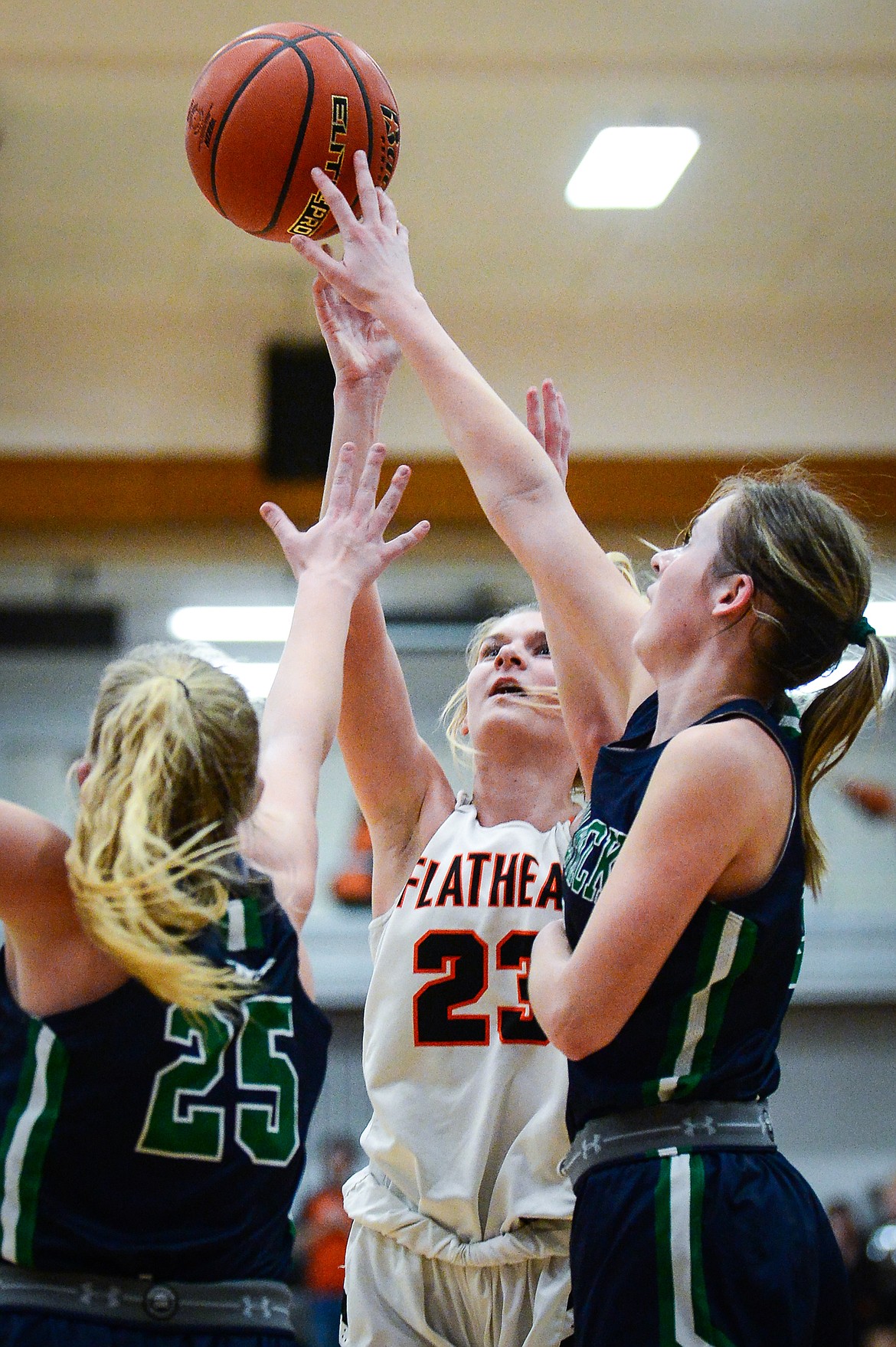 Flathead's Cecilia Vandenbosch (23) shoots over Glacier defenders Cazzland Rankosky (25) and Sarah Downs (2) in the first half at Flathead High School on Thursday, Feb. 16. (Casey Kreider/Daily Inter Lake)