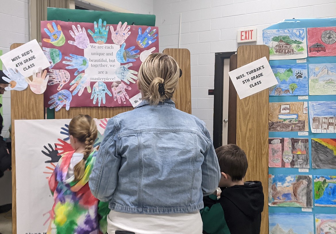 A family viewing artwork that was created by elementary students at Silver Hills, displayed during the art night.