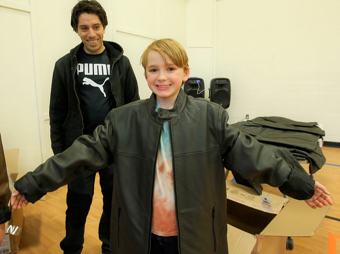 Liam Munsey enjoys the long sleeves on his new coat he received Thursday at the Boys and Girls Club in Coeur d'Alene, while volunteer Joel Angel looks on.