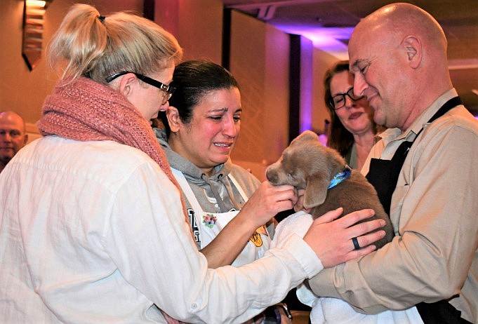 People swoon over a puppy at the North Idaho's 38th annual Wine Taste and Auction at The Coeur d'Alene Resort.