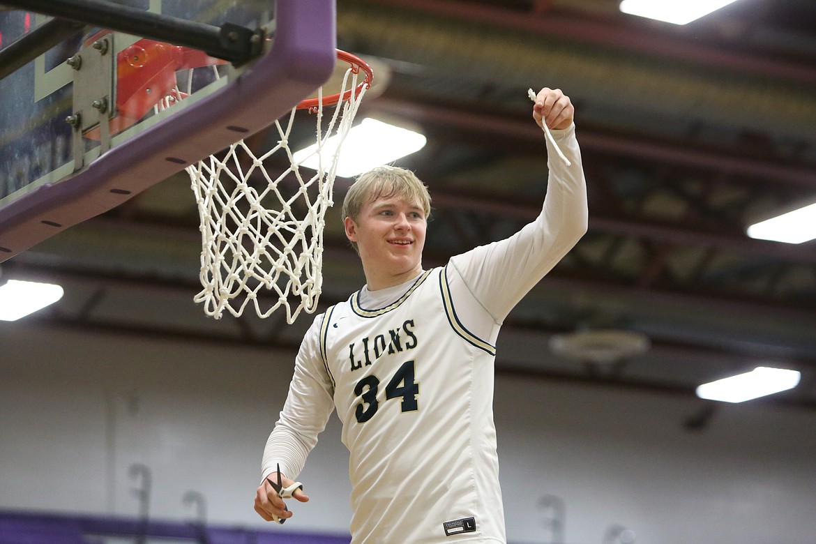 MLCA/CCS junior Jonah Robertson smiles while showing off a piece of the cut net in celebration of the Lion’s 59-58 win over Riverside Christian.