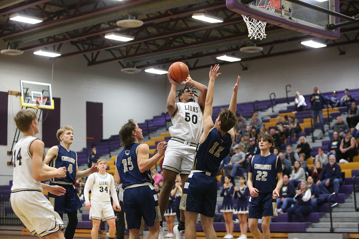 MLCA/CCS junior Caleb Jones (50) fights through contact while shooting a jump shot in front of the rim in the first half against Riverside Christian.